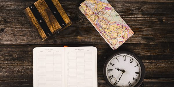 elevated-view-diary-map-clock-wooden-background